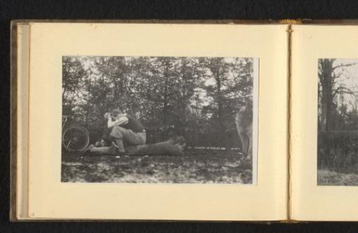 Three people on the ground in the forest, a dog on the right