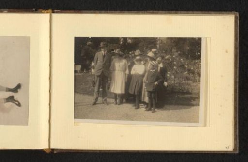 Group portrait with nine persons in front of a flower bed