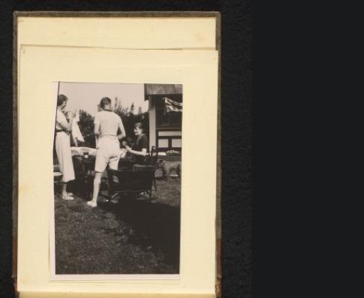 People on a terrace in a garden, a dog on the right