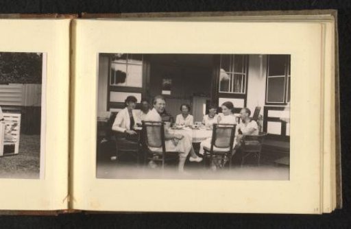 People at a table on a terrace in a garden