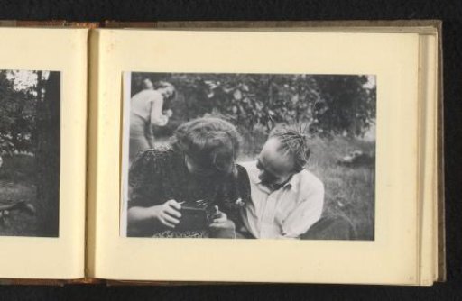 Woman and man, with branches in his hair, looking at a camera