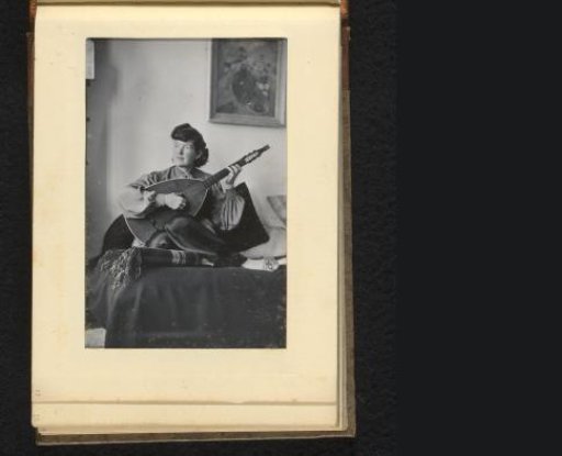 Woman with a lute sitting on a bed