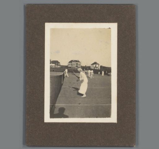 Woman playing tennis, shadow of the photographer in the lower left