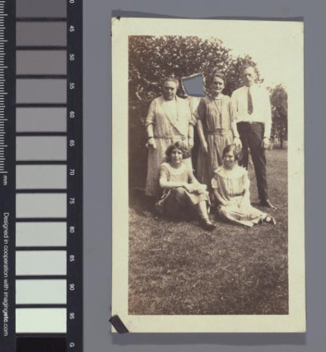 Group portrait with five people, of whom the head of one person has been cut out