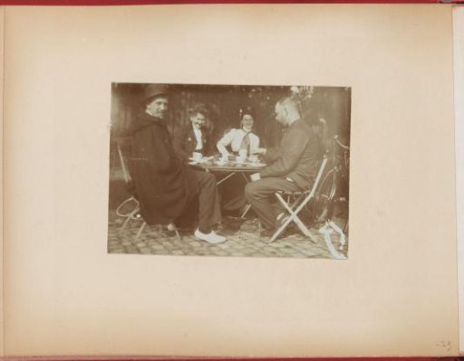 Two men and women at a small table at a tennis club