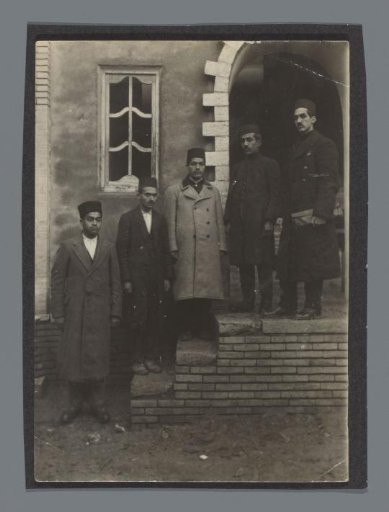 Five men, Tavakoli (far right) with a portfolio on the steps in front of a building
