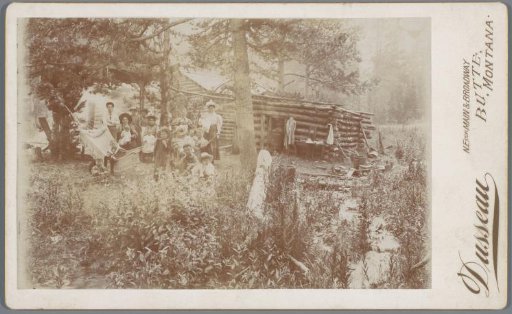 Family posing in front of a forest hut, Butte, Montana