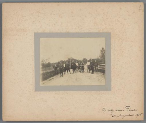 Group portrait of unknown men, partly with bicycles, on the road to Thusis