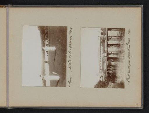 Two women in a field with cows and view of a wooden bridge with people and an iron bridge