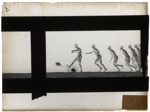 Man taking a run-up and kicking the ball away