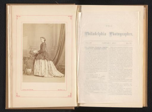 Portrait of an unknown standing young woman at a table