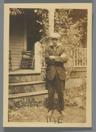 Portrait of a boy with a cap in front of a veranda
