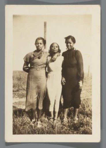 Portrait of three women posing in a field