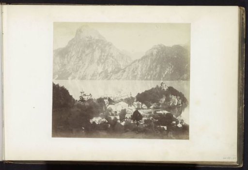 View of a mountain lake with buildings on the shore, possibly in the Alps