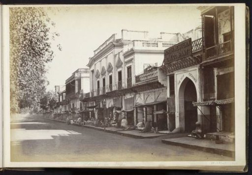 Street view with shops such as the North Western Dâk Company and the entrance of the Delhi Exchange, Delhi, India