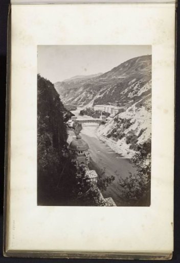 Mountain gorge with village and river, presumably in the Alps