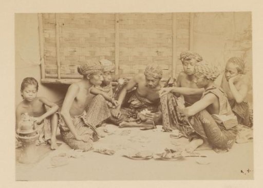 Men playing cards, sitting on the ground