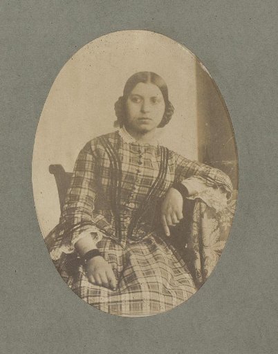 Portrait of a young woman with elbow resting on table