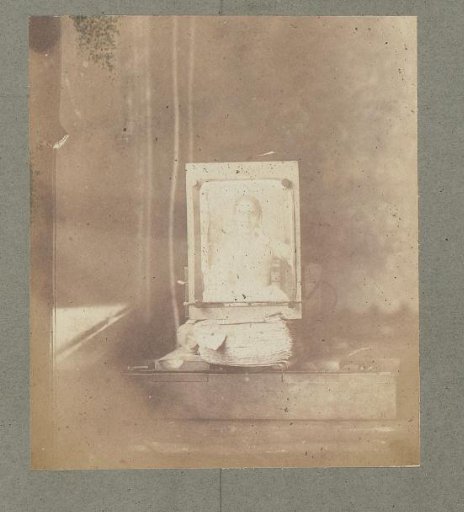 Photograph showing a portrait of a girl framed on a desk