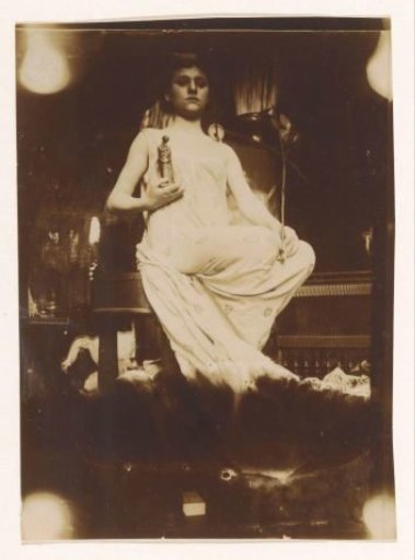 Woman seated on a pedestal with a figurine in her hands