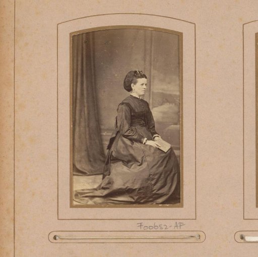 Portrait of a woman with a book in her hand, seated on a chair