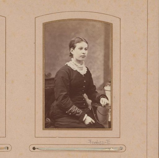 Portrait of a young woman, seated at a table