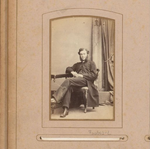 Portrait of a man in a long coat, seated on a chair