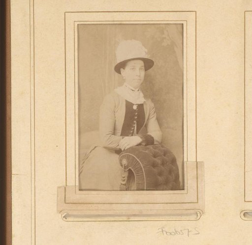 Portrait of a woman with a hat, leaning on a chair