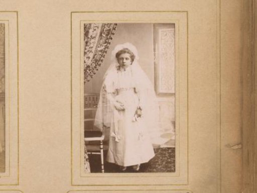 Portrait of a girl in a white dress, presumably for first communion