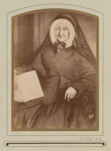 Photographic reproduction of a painting of a portrait of a pious woman in black clothing with cap and Book of the Bleeding Heart
