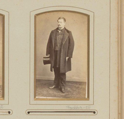 Portrait of a standing man with a hat in his hand