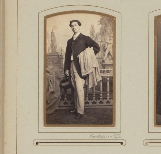 Portrait of a standing man with coat and hat in hand