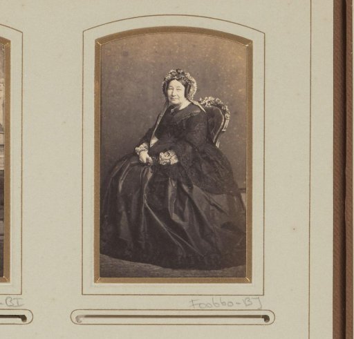 Portrait of a seated woman with headgear