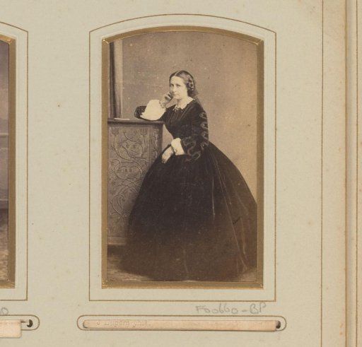 Portrait of a standing young woman, leaning on a cabinet