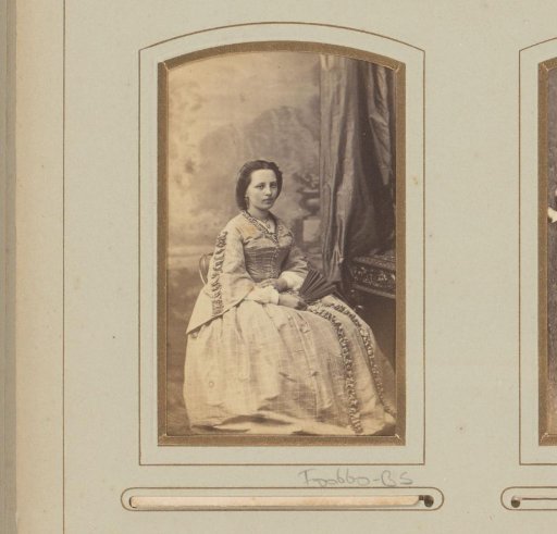 Portrait of a seated woman with fan in her hand