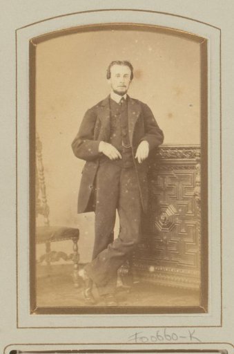 Portrait of a man, leaning on a cabinet