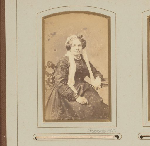 Portrait of a seated woman with headgear