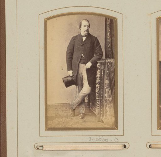 Portrait of a man with hat in hand, leaning on a cabinet