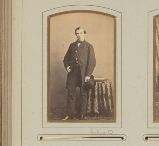 Portrait of a standing man with hat in hand, before a table