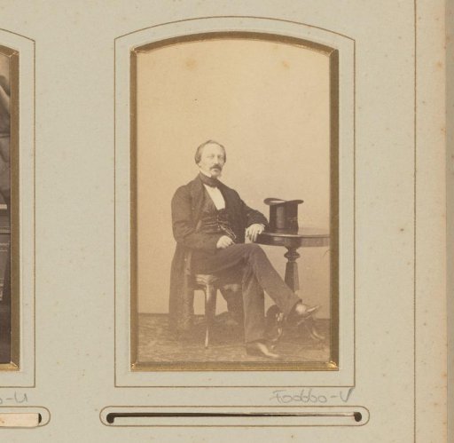 Portrait of a man at a table with a hat lying on it