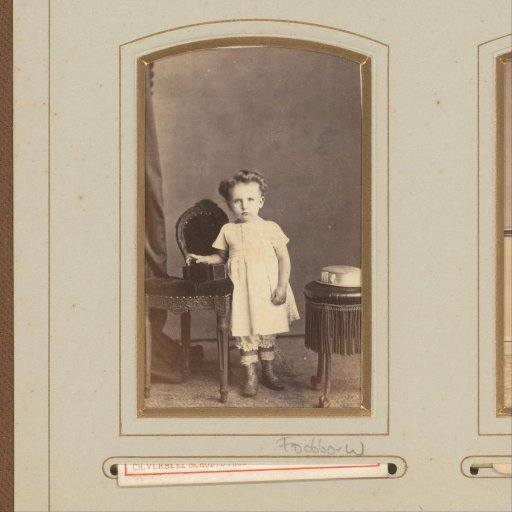 Portrait of a young girl by a chair with a camera