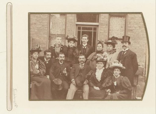 Group portrait of men and women in front of a house