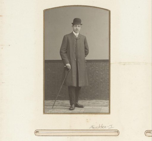 Portrait of a standing man with a bowler hat and walking stick