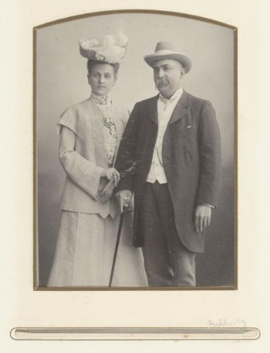 Portrait of a man with a walking stick and hat and a woman with a hat
