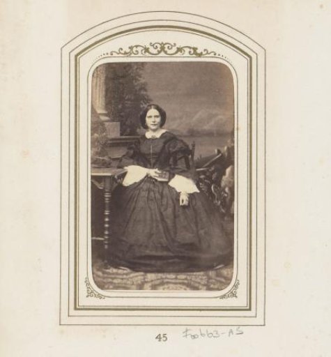 Portrait of a seated woman in front of a backdrop