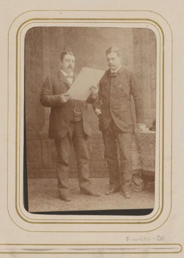 Portrait of two men with a pamphlet
