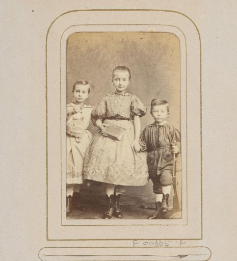 Group Portrait of Three Children with a Book and Toys