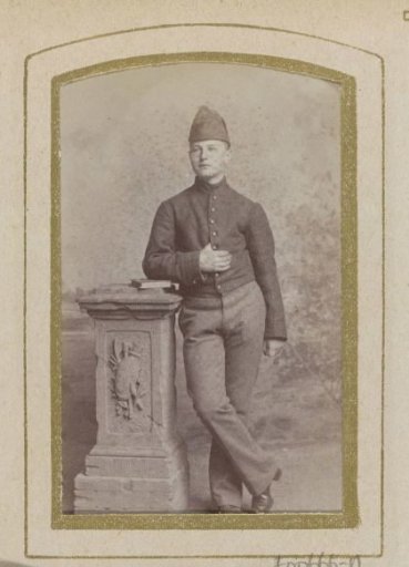 Portrait of a young man in uniform by a pillar