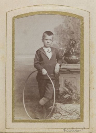 Portrait of a boy with a hoop by a pillar