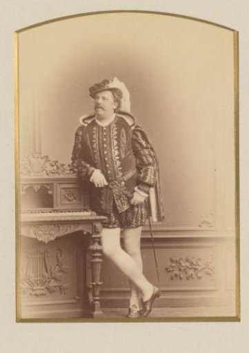 Portrait of Gustav Gunz, standing in masquerade costume by a desk
